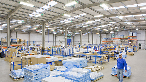 Man pulling supplies in a well lit warehouse Man pulling supplies in a well lit warehouse