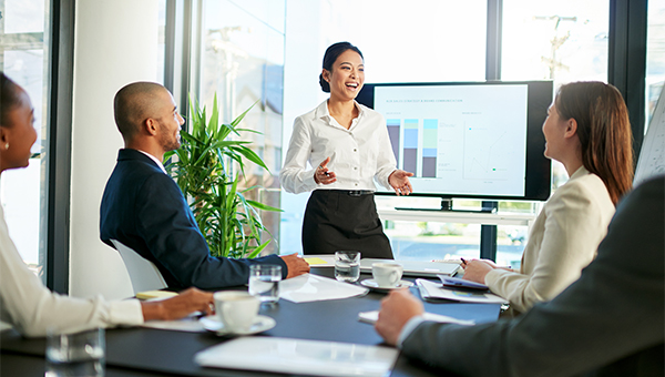 Woman smiling while presenting to colleagues