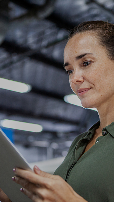 Woman looking at a tablet in a warehouse