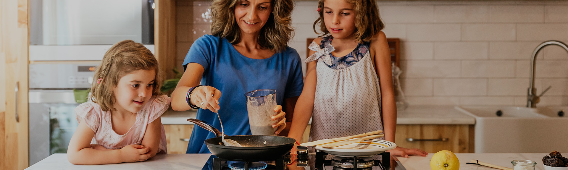 Mother and daughter cooking pancakes in their kitchen