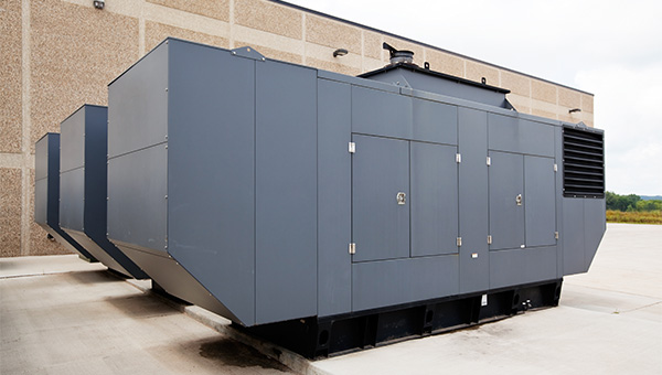 Three grey backup generators outside