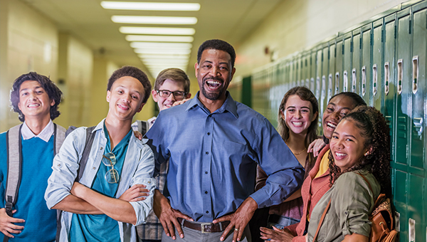 Teacher and students standing in the hall at school