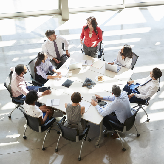High angle shot of employees sitting at a desk having a staff meeting