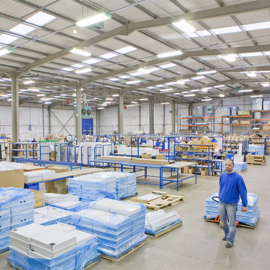 Man pulling wooden pallets in side a warehouse