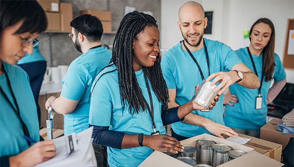 Group of employees in blue shirts volunteering at a food bank