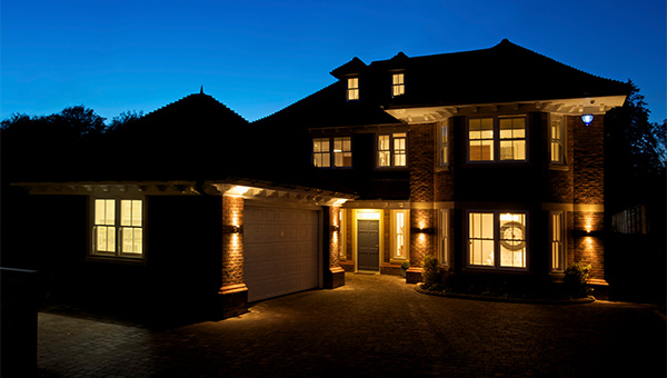 Two story house with lights on at night