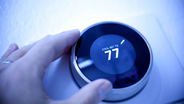 Hand adjusting the digital thermostat Hand adjusting the digital thermostat