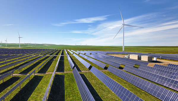 Wind turbines and solar panels in a field Wind turbines and solar panels in a field