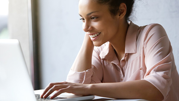Woman smiling while looking at her laptop