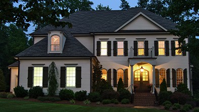 Night time, Wood home with front porch and all lights on.