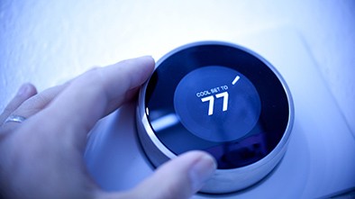 Man’s hand adjusting thermostat.