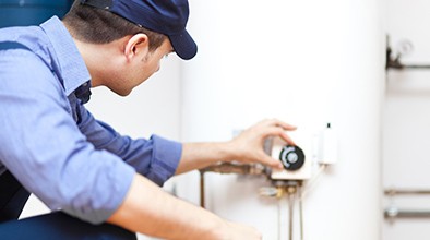 Blue Collar worker adjusting water heater.