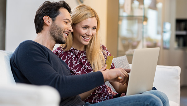 Husband and wife smiling at a laptop screen together